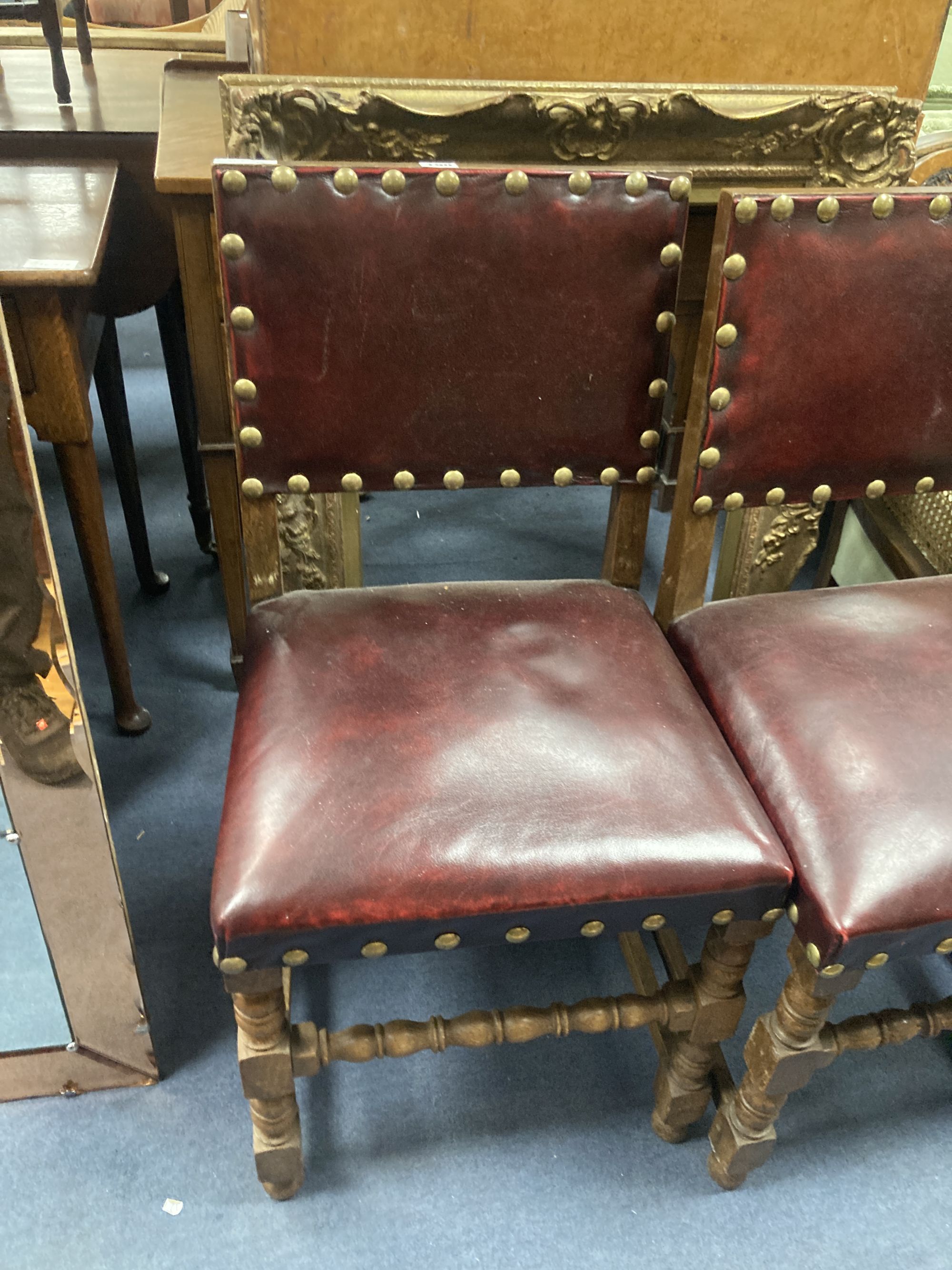 A pair of oak carolean-style dining chairs circa 1880, red leather and studding